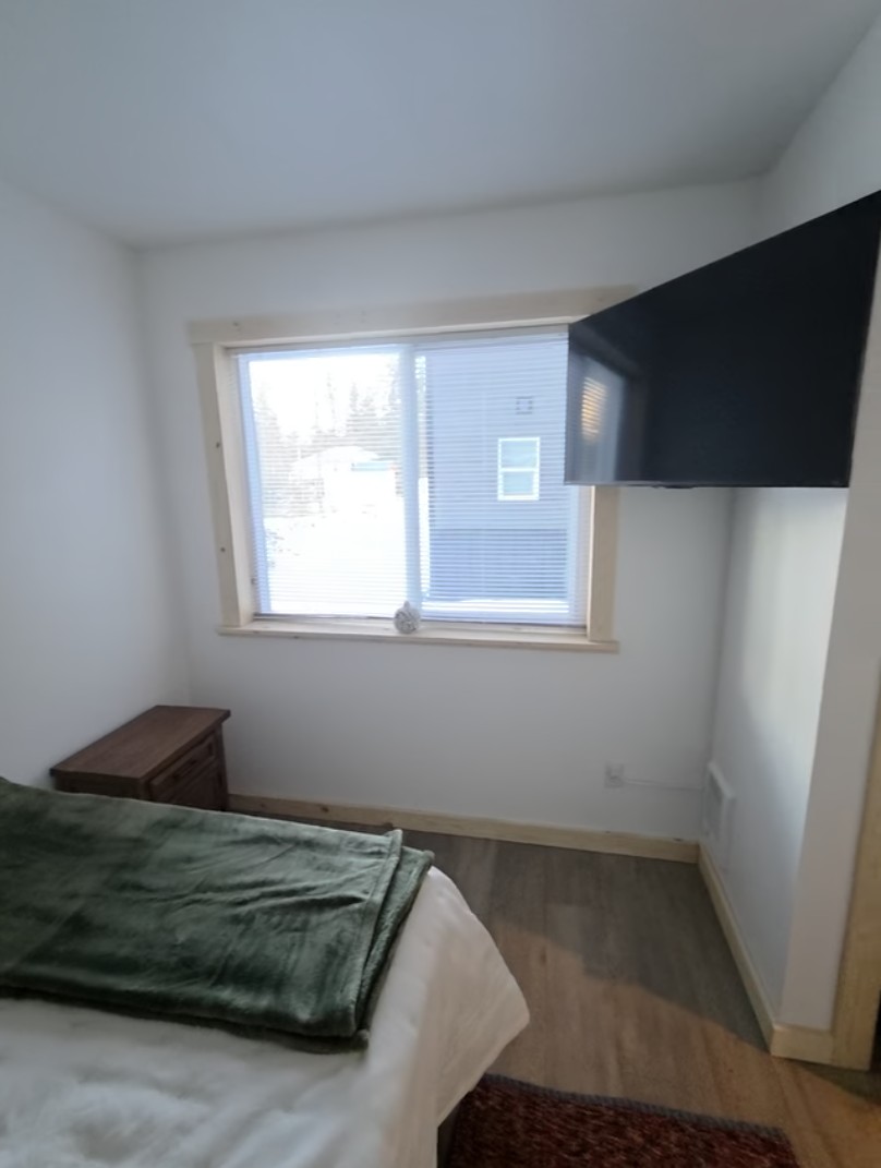 Bedroom on main floor includes a queen size bed, nightstand, closet and TV [Photo is representative but is not from this cabin].