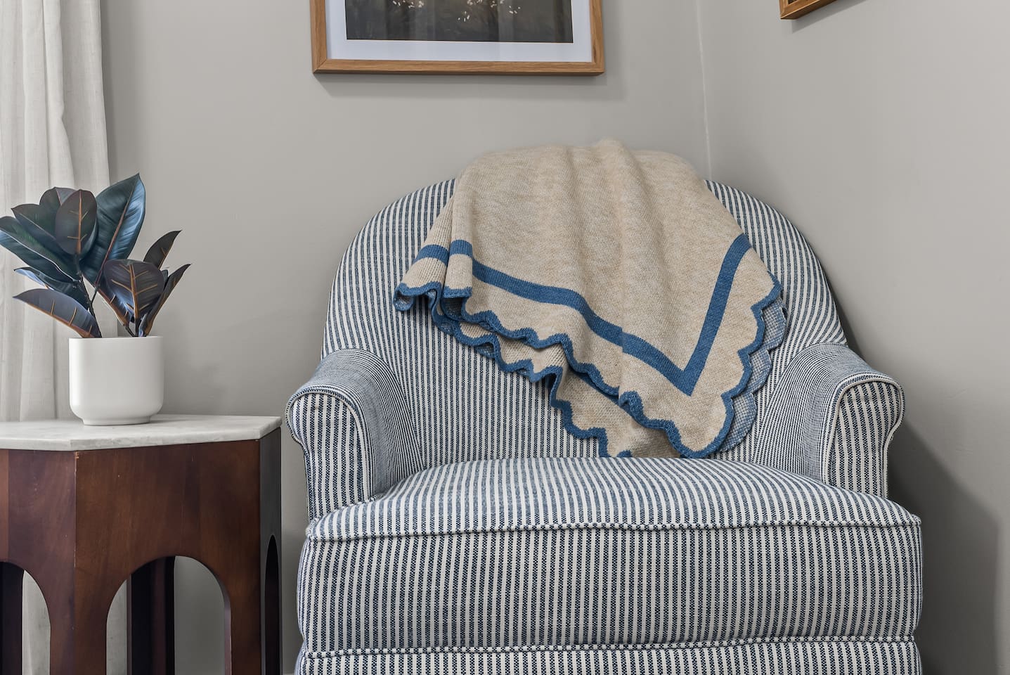 A plush armchair with a cozy throw invites you to curl up and relax.