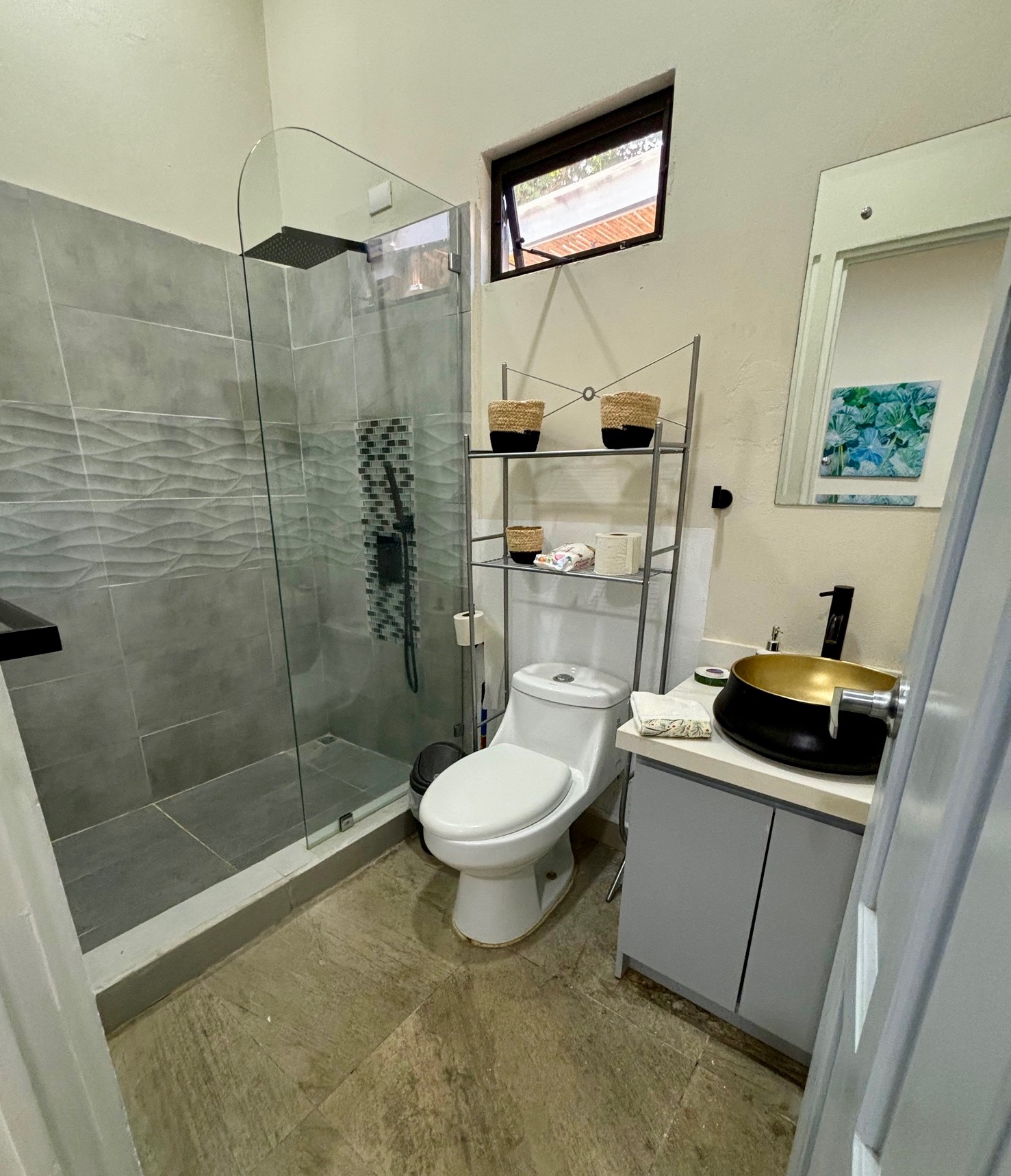 The second bathroom has a tiled walk-in rain shower and copper sink