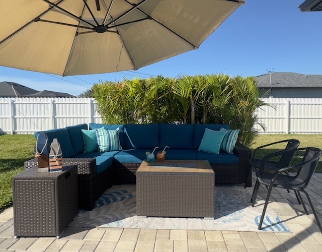Patio lounging with oversized adjustable umbrella, fire pit table.