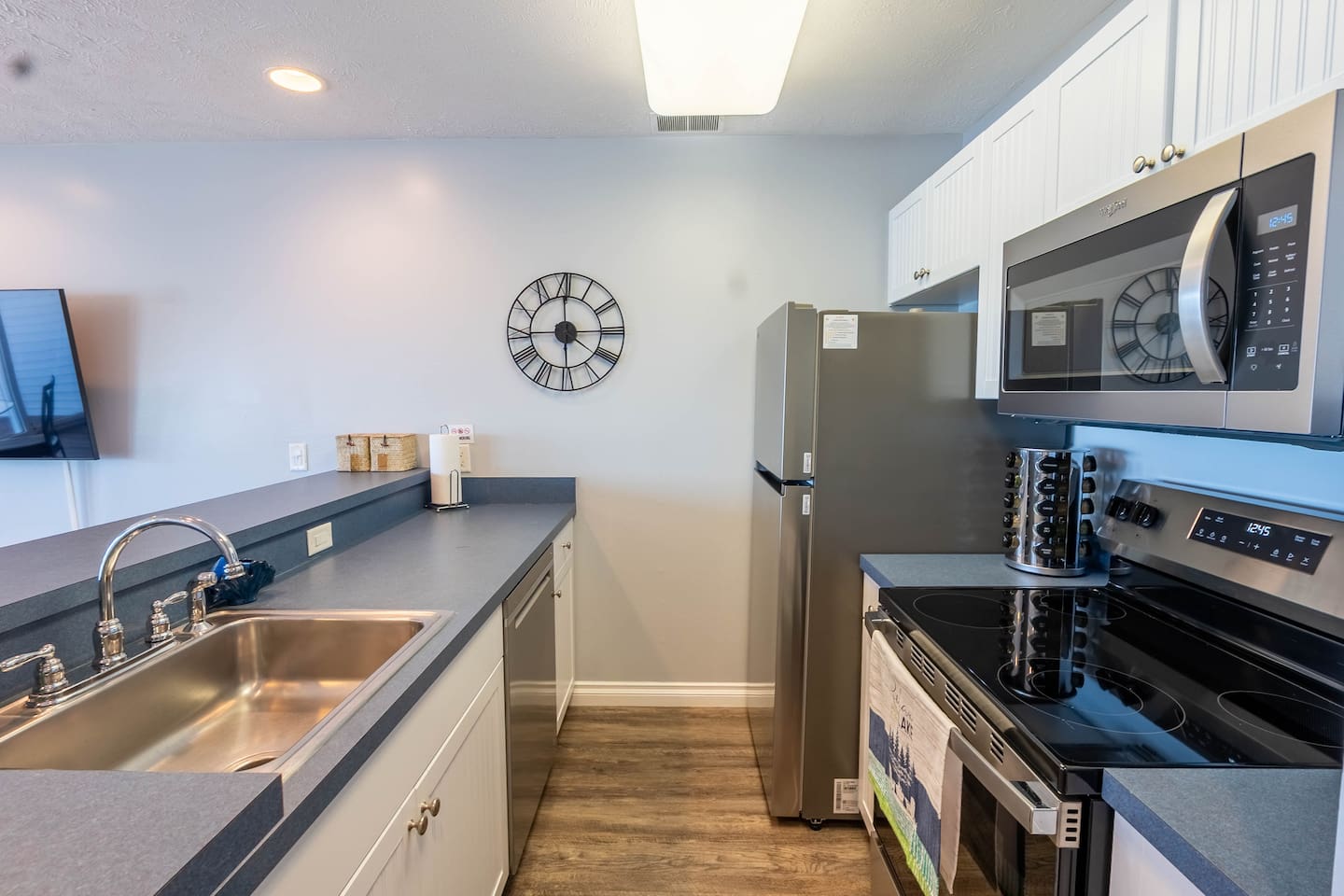 Full kitchen stocked with cups, plates, silverware, cooking utensils, and spice rack. Brita filtered water system in the fridge.