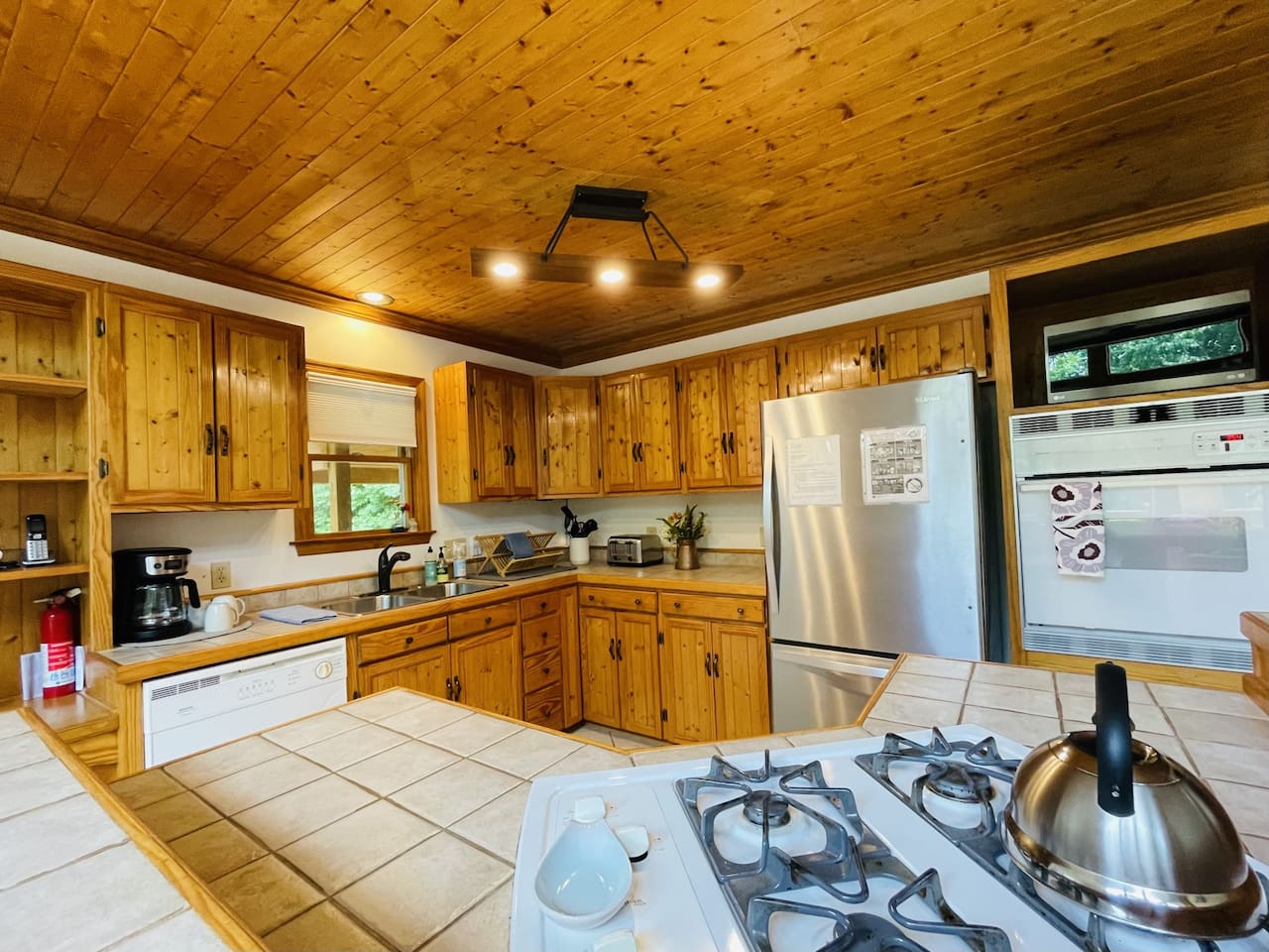 The kitchen has a propane cooktop with prep space, a wall oven, and everything else you could need. Super well stocked