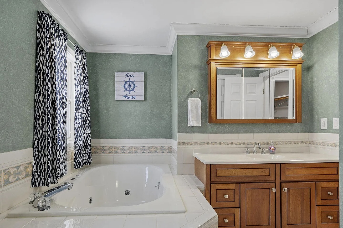 The primary bath offers generous space with a large tub and separate shower, while preserving the home's classic original design and character.