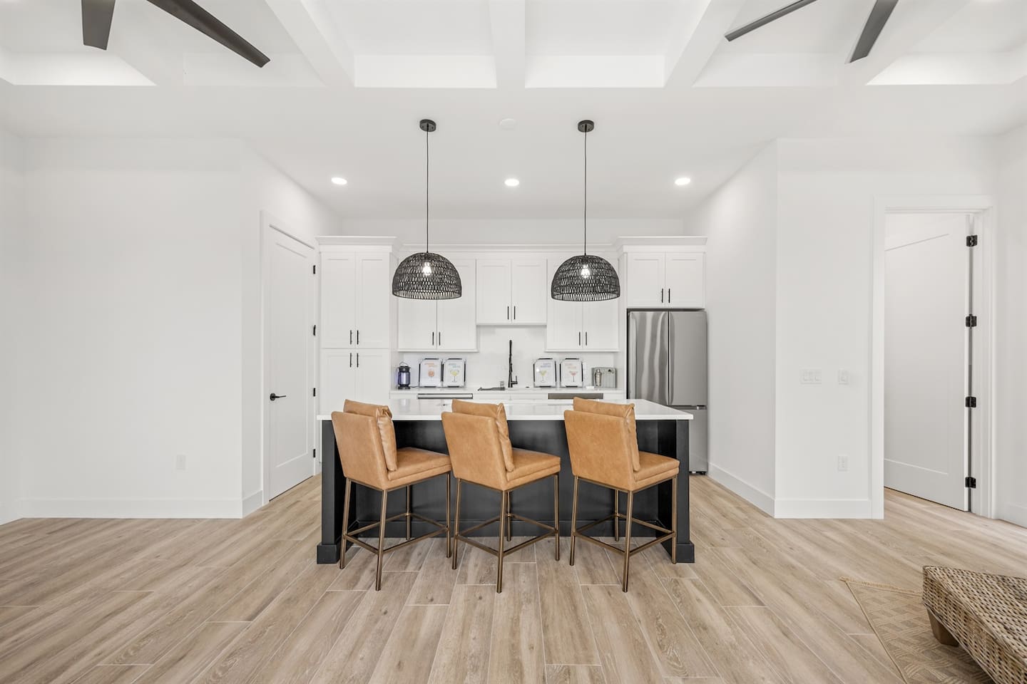 Featuring stylish chairs, granite tables with lit countertops, a chandelier fan, a refrigerator, and sleek flooring, creating a sophisticated and inviting space for gatherings or relaxation.
