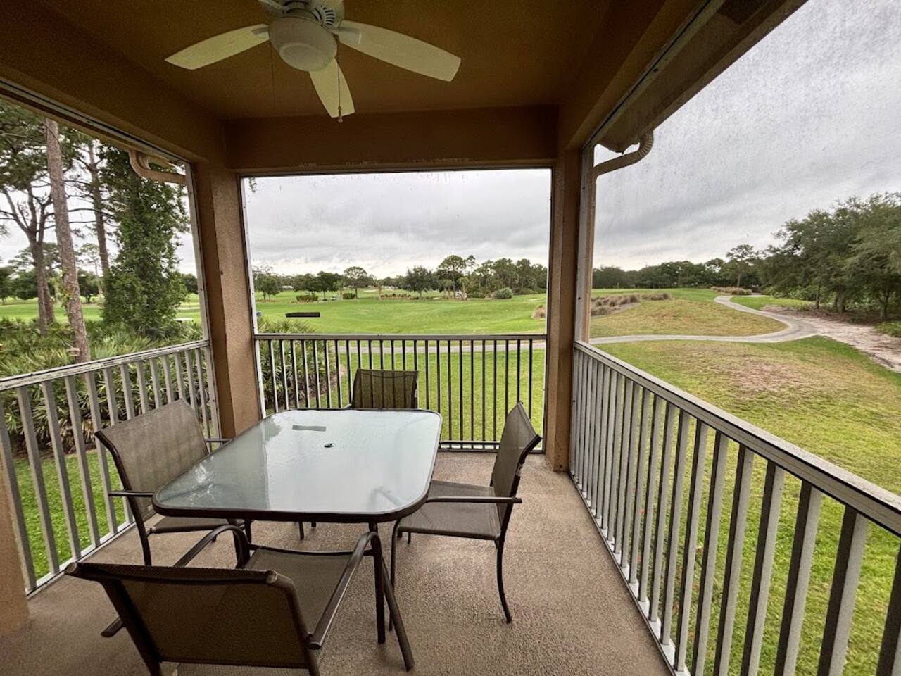 Private screened balcony with outdoor dining space and relaxing views of the surrounding green space.