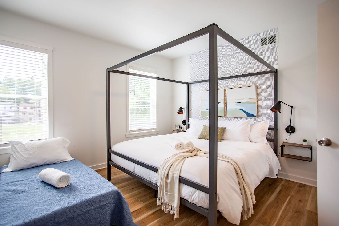 Spacious king bed complemented by an additional single bed, offering flexible sleeping arrangements for couples, families, or extra guests.