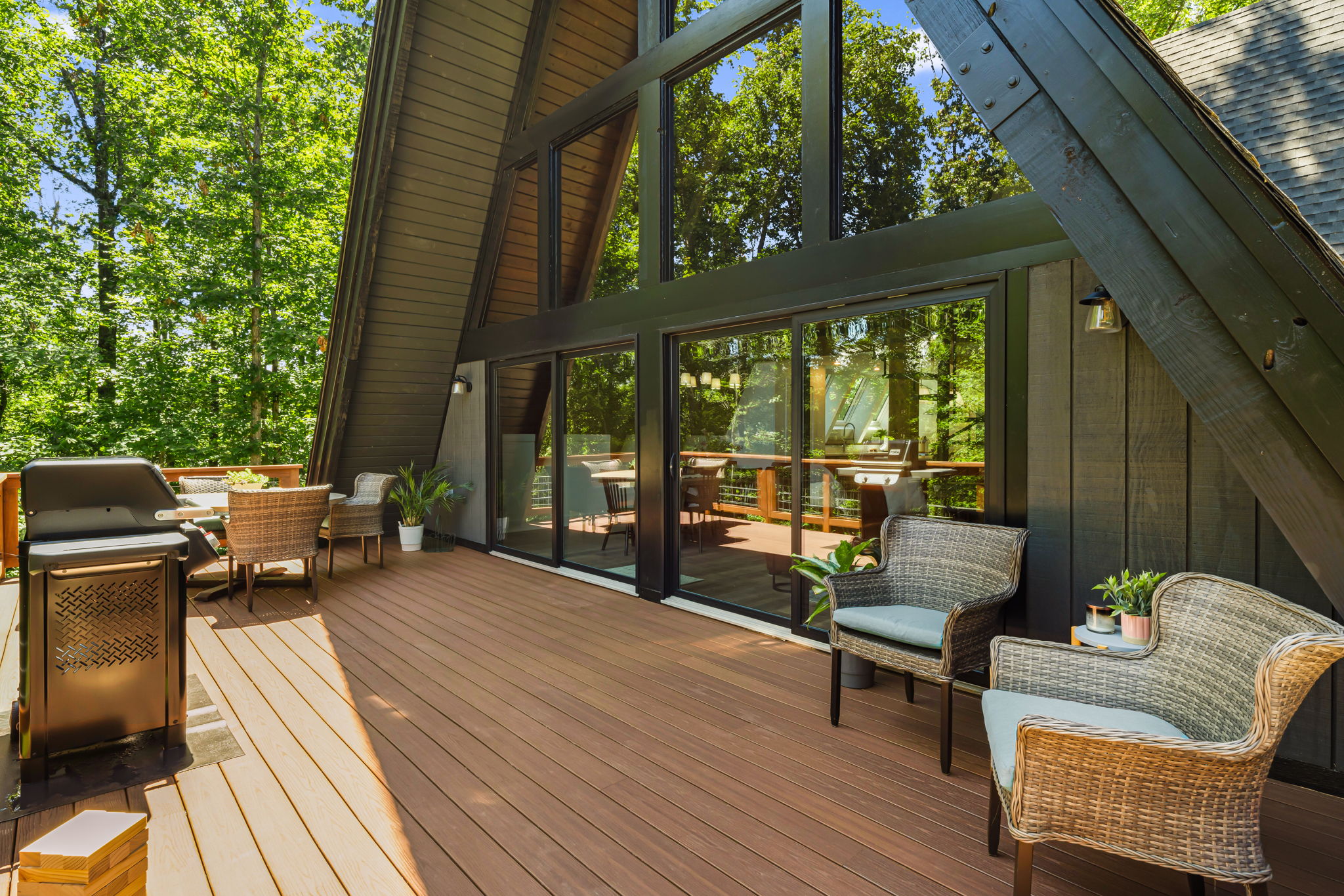 Spacious main deck with a dining table that sits 6 people and a gas grill, all overlooking the backyard and natural area.
