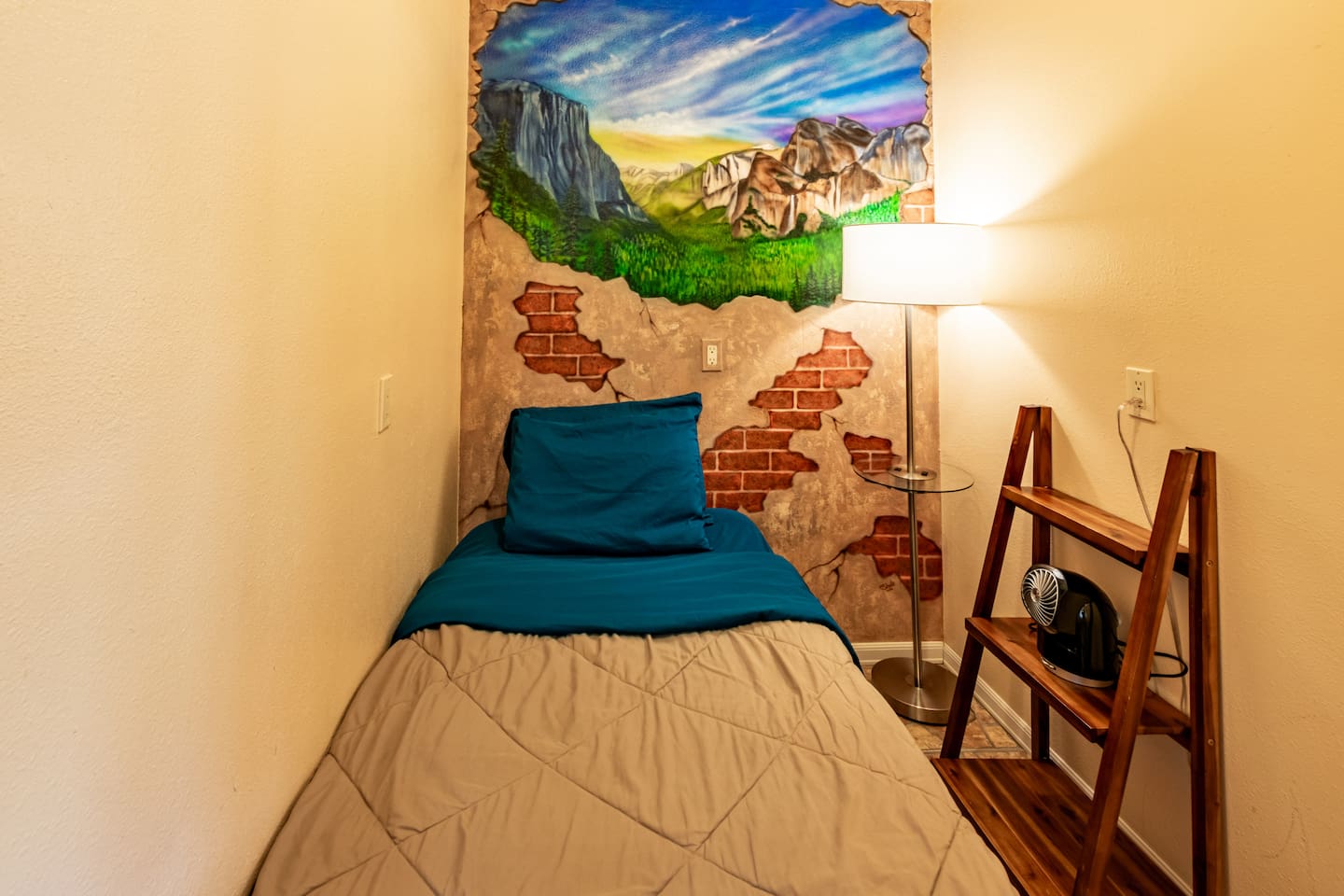 Single bed is located in pantry room. Drawing of Half Dome on the wall is painted by local artist.