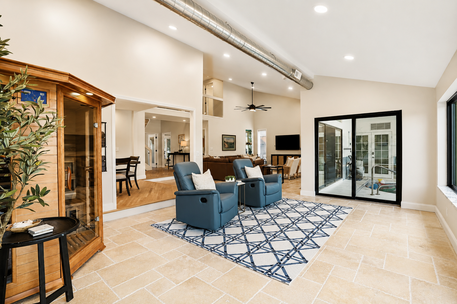 Bright, open-concept living space with high ceilings, modern seating, and seamless flow between indoor and outdoor areas. Stylish, airy design perfect for relaxing, entertaining, and enjoying group stays.
