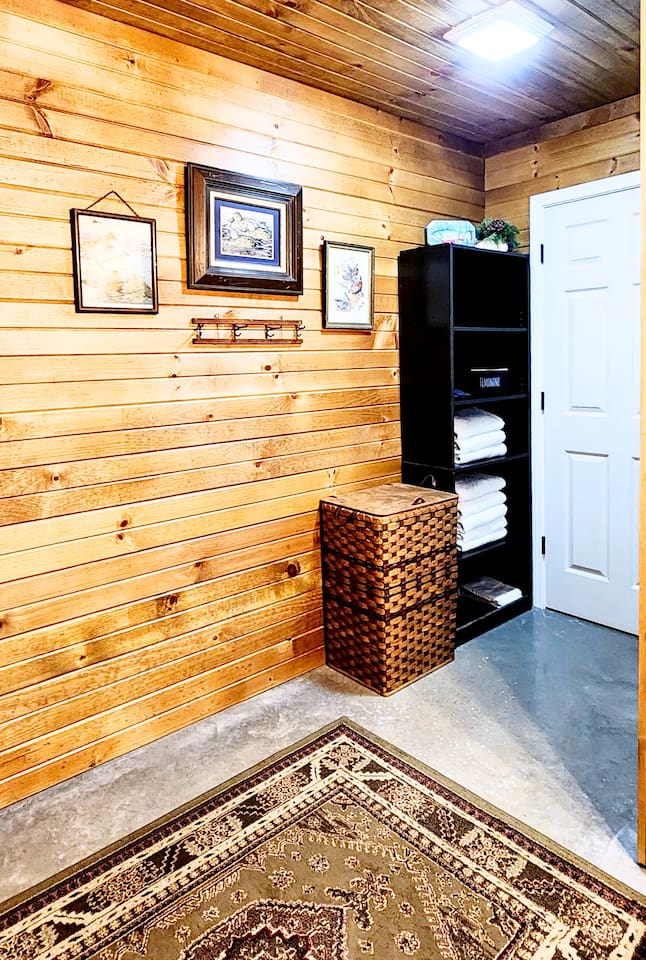 The bathroom features a spacious shelf stocked with plush towels and a large laundry hamper. Guests will appreciate the added storage space to neatly tuck away their personal belongings during their stay.