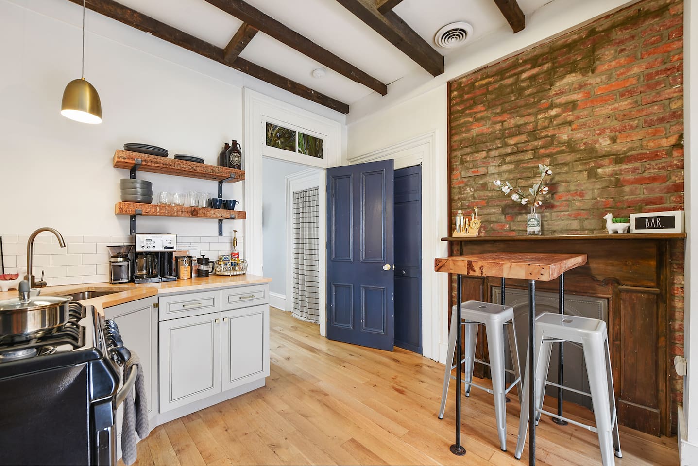 Enjoy a well-equipped kitchen with a sleek center table, a cozy brick wall accent, and modern appliances—plus a coffee maker to start your day right!