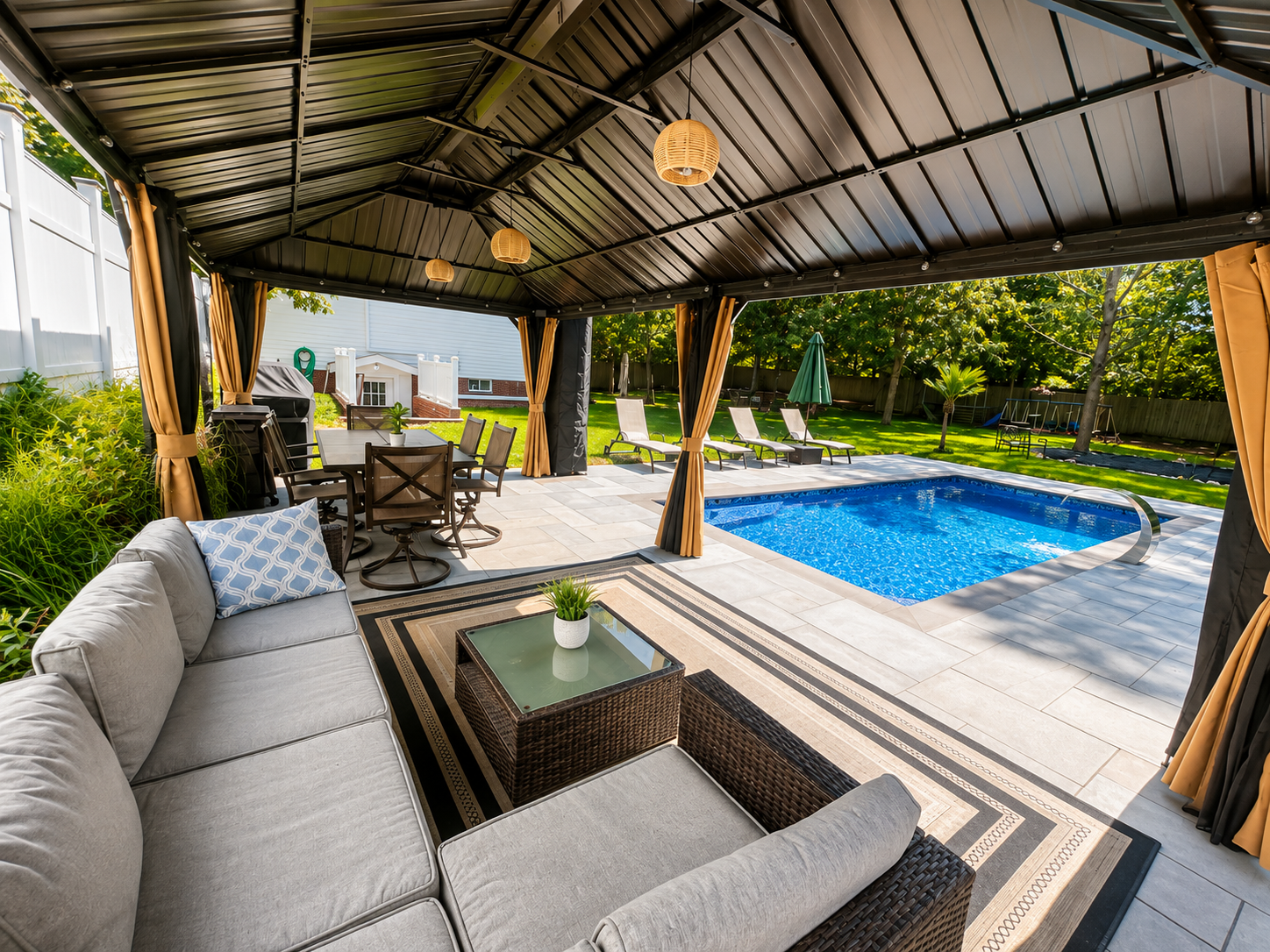 Covered outdoor lounge with plush seating overlooking the pool
