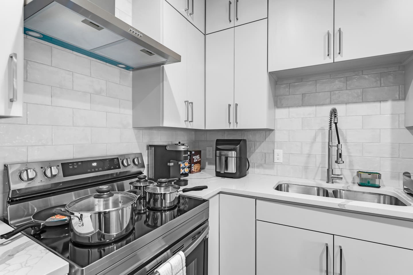 Fully stocked kitchen with cookware, cutlery, and modern appliances ready for home-cooked meals.