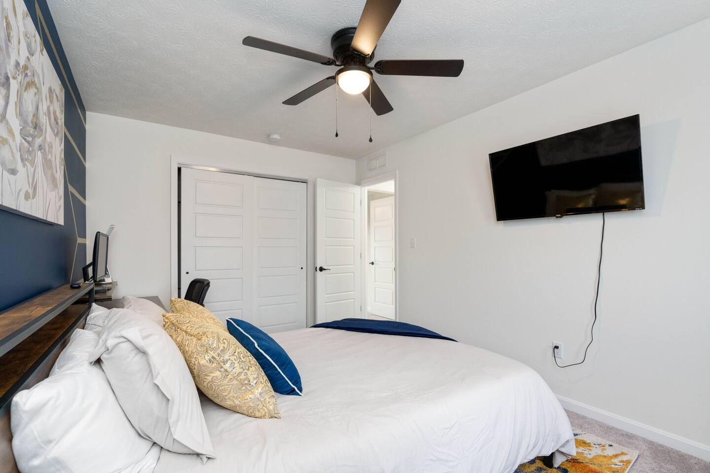 secondary bedroom featuring, queen bed, tv, work space