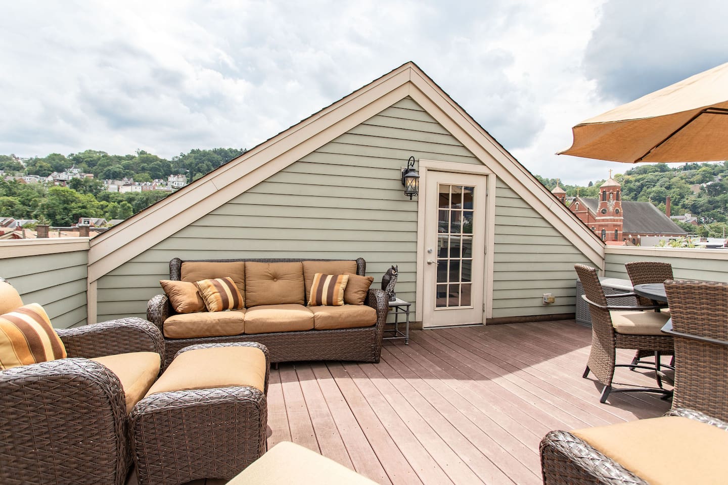 Charming rooftop with comfy couches, chairs, and a table, offering the perfect space to relax, dine, or enjoy the view in comfort.