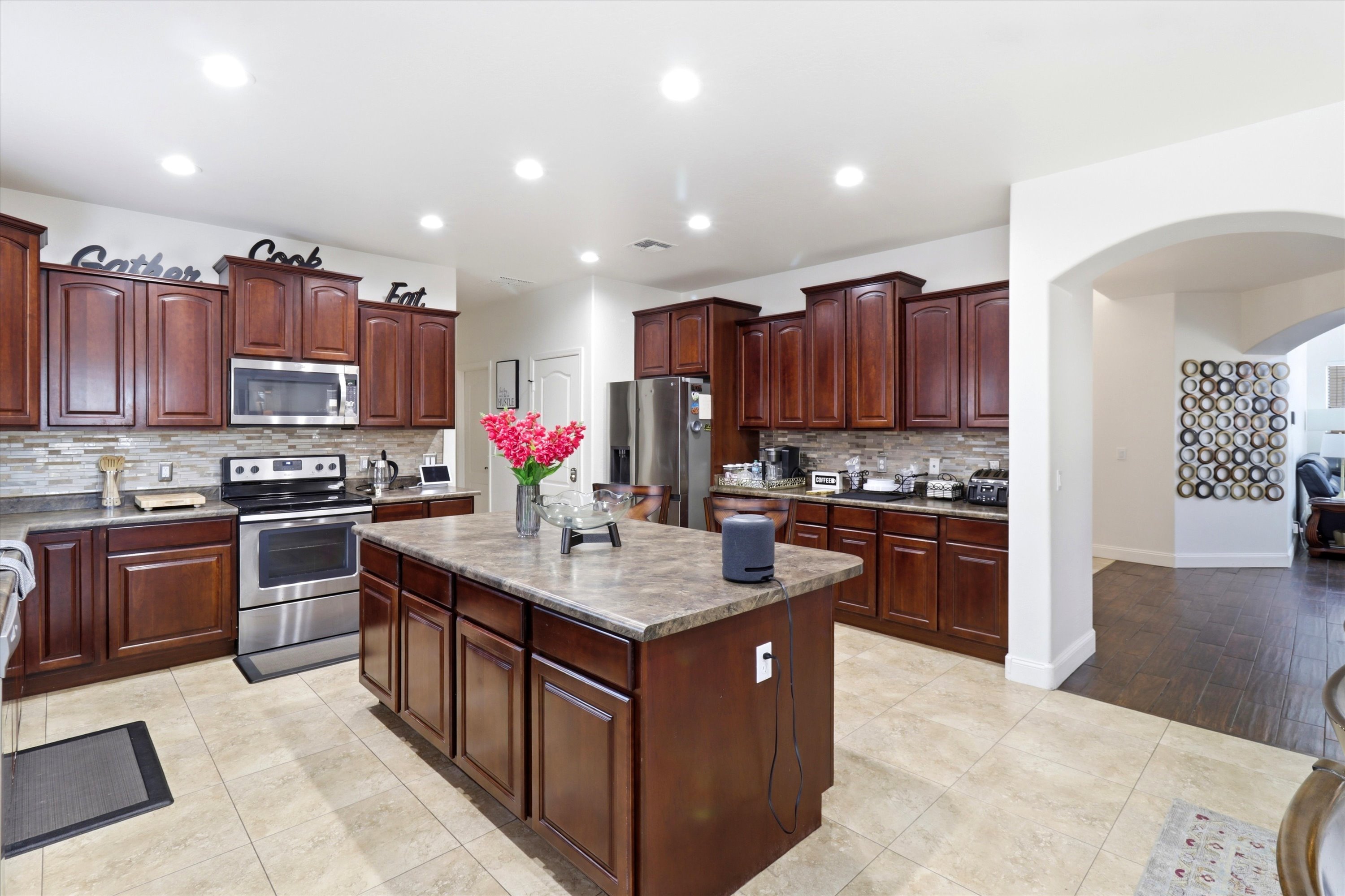 Kitchen with a large center island, dark wood cabinets, full appliances, and plenty of room for meal prep.
