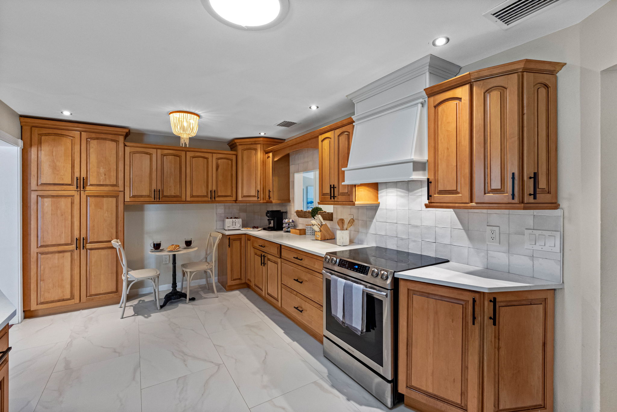 This spacious kitchen features warm wood cabinetry, sleek stainless steel appliances, and a bright open layout.