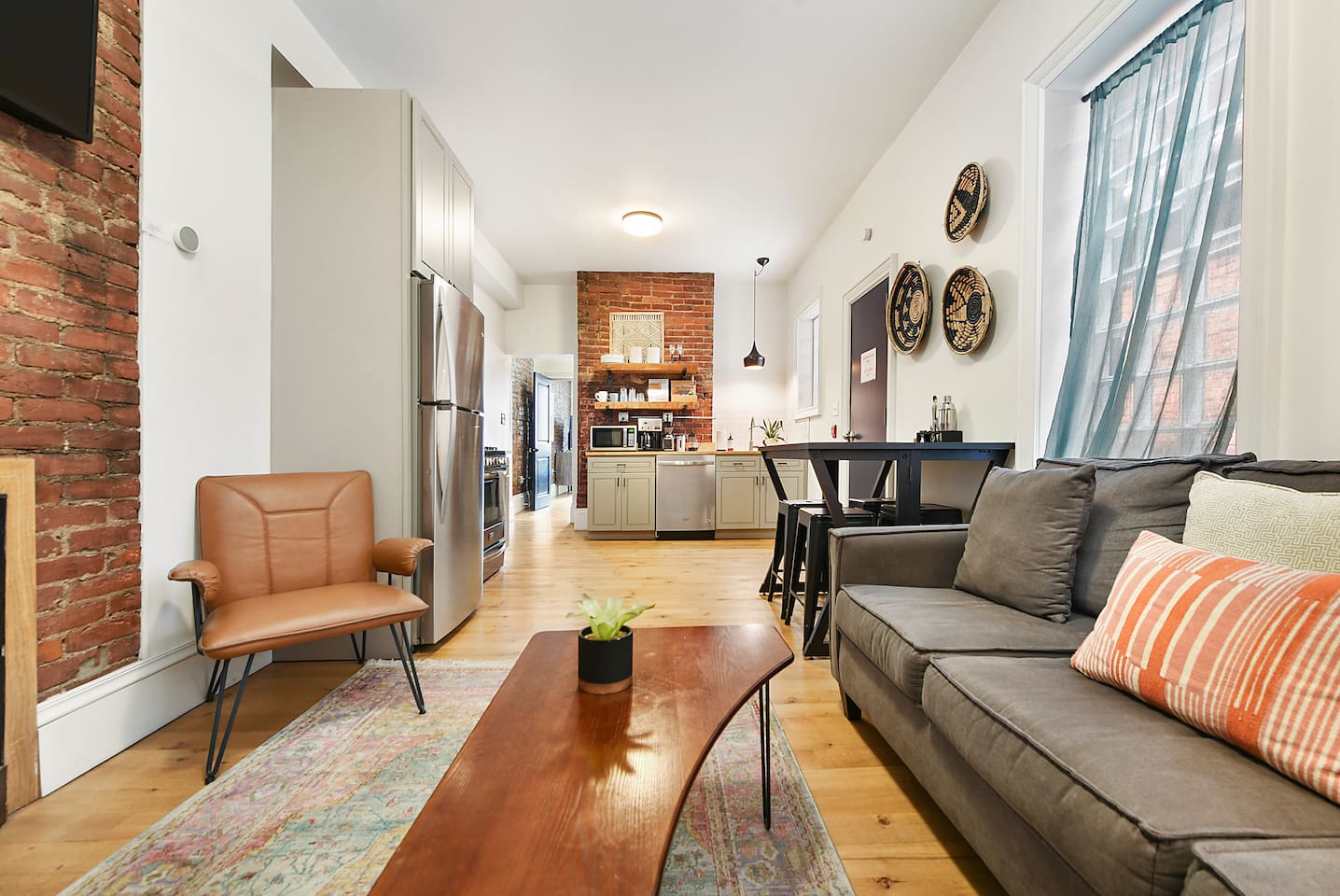 Unwind in comfort! This cozy space features a plush couch, an extra chair, a stylish coffee table, and a soft rug—all bathed in natural light from a huge window. Perfect for relaxing after a day of exploring!