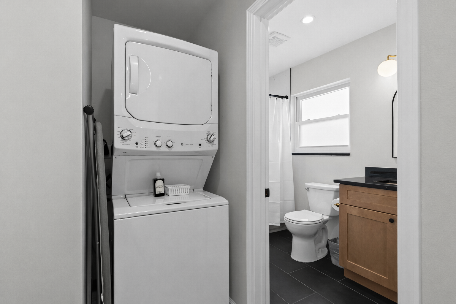 Convenient in-unit laundry tucked beside a modern bathroom—making longer stays easy, comfortable, and stress-free.
