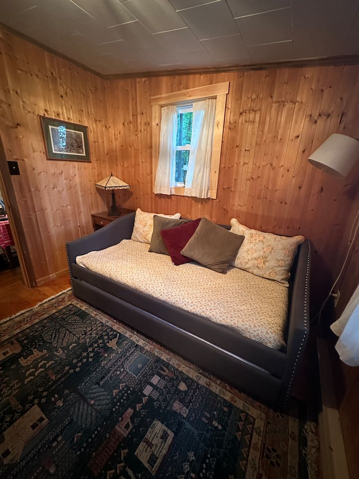 This twin bed with pull-out trundle is perfect for kids or extra guests. Bright and airy with dresser storage, it’s a cozy nook for rest or quiet time.