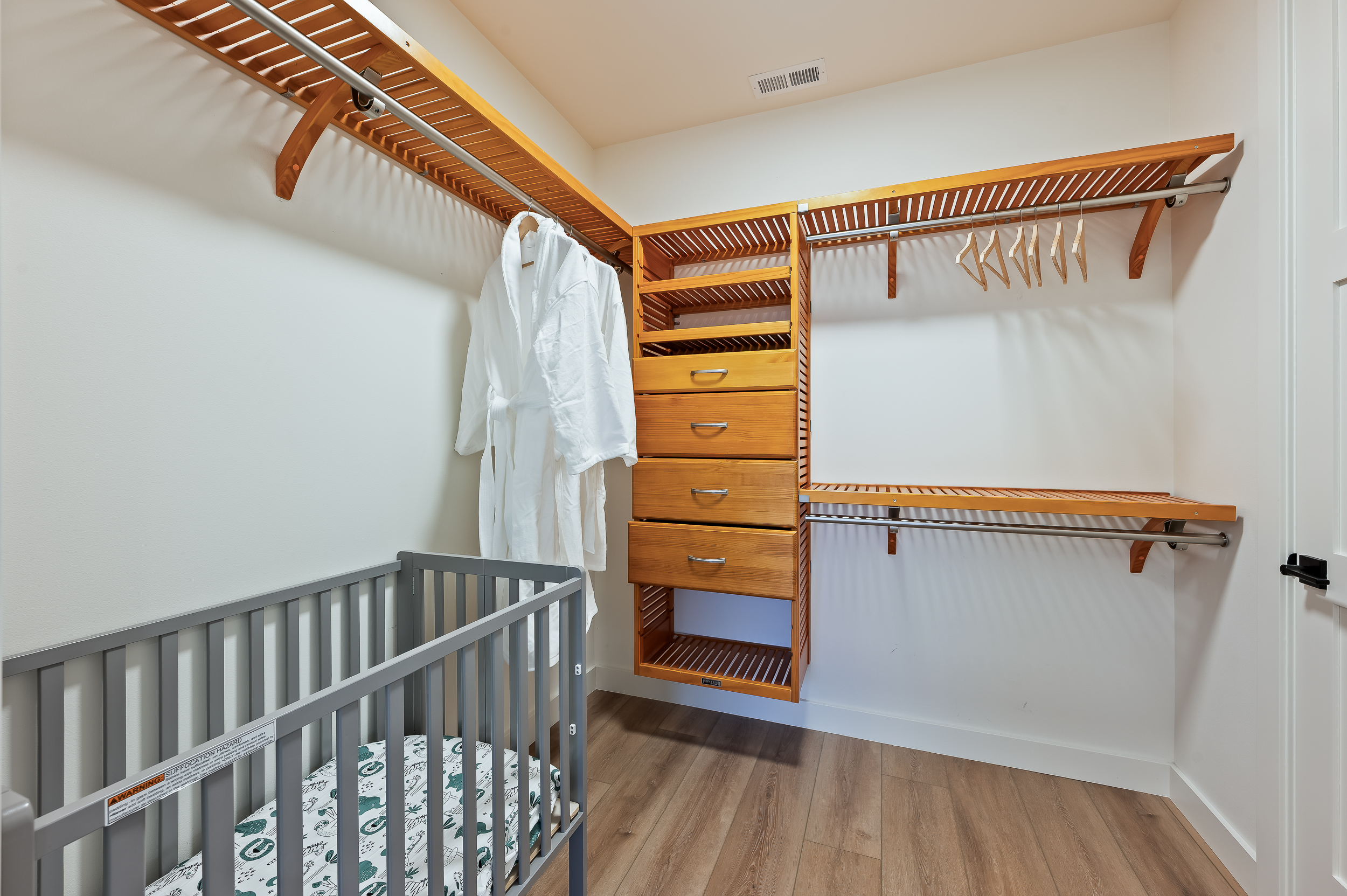 Primary bedroom walk-in closet with crib