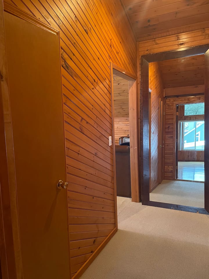 warm wood interior hallway with a large mirror connecting the cabin spaces.