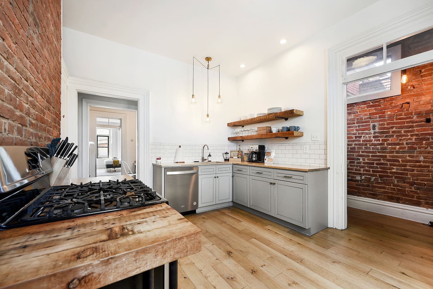 This kitchen features a beautiful brick wall and comes fully stocked with all cooking essentials, including a coffee maker. Whether preparing meals or enjoying your morning coffee, this space is designed for function and style.
