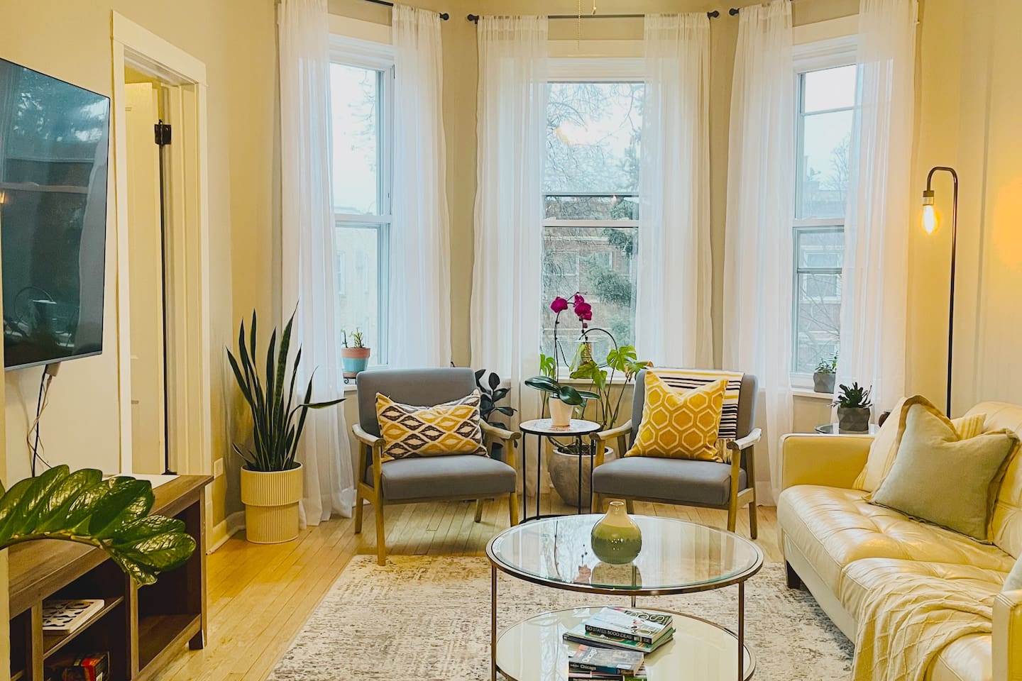 Bright and inviting living room with large windows and comfortable seating — perfect for relaxing after exploring Chicago.