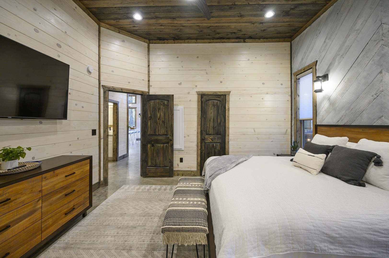 Cozy bedroom retreat featuring warm wood tones, soft bedding, and a peaceful view to start and end your day.