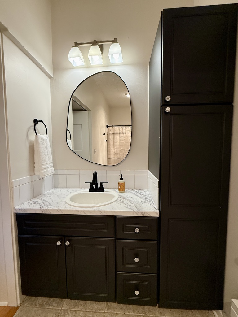 Large full ensuite bathroom attached to the second bedroom with updated fixtures, heat lamp, elongated oval toilet, high ceilings.