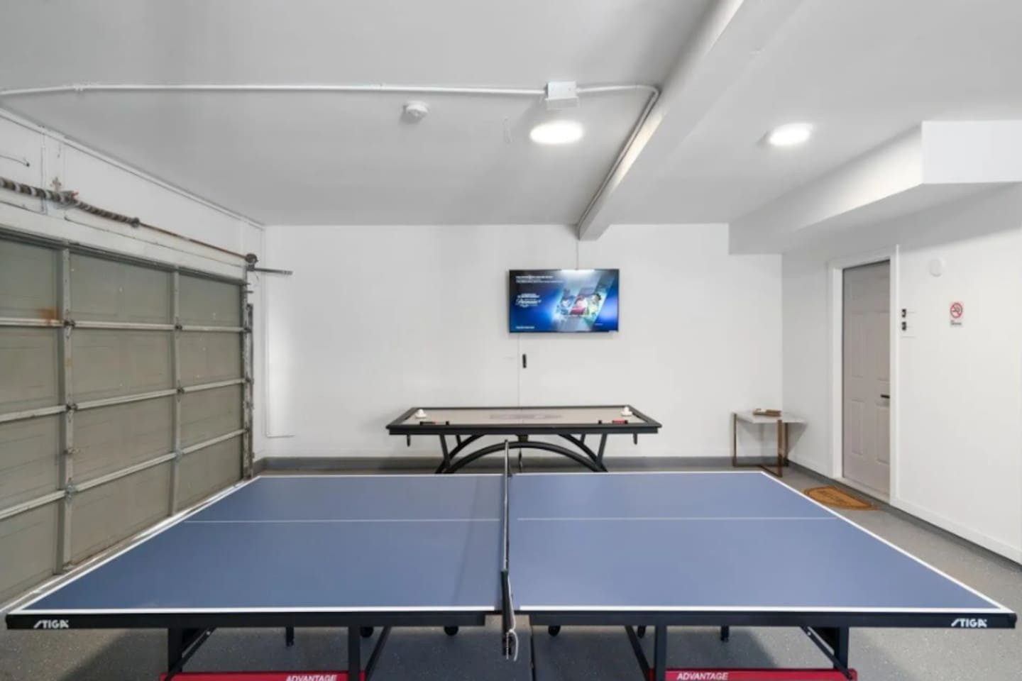 Recreation garage with professional ping pong and pool tables for indoor entertainment.