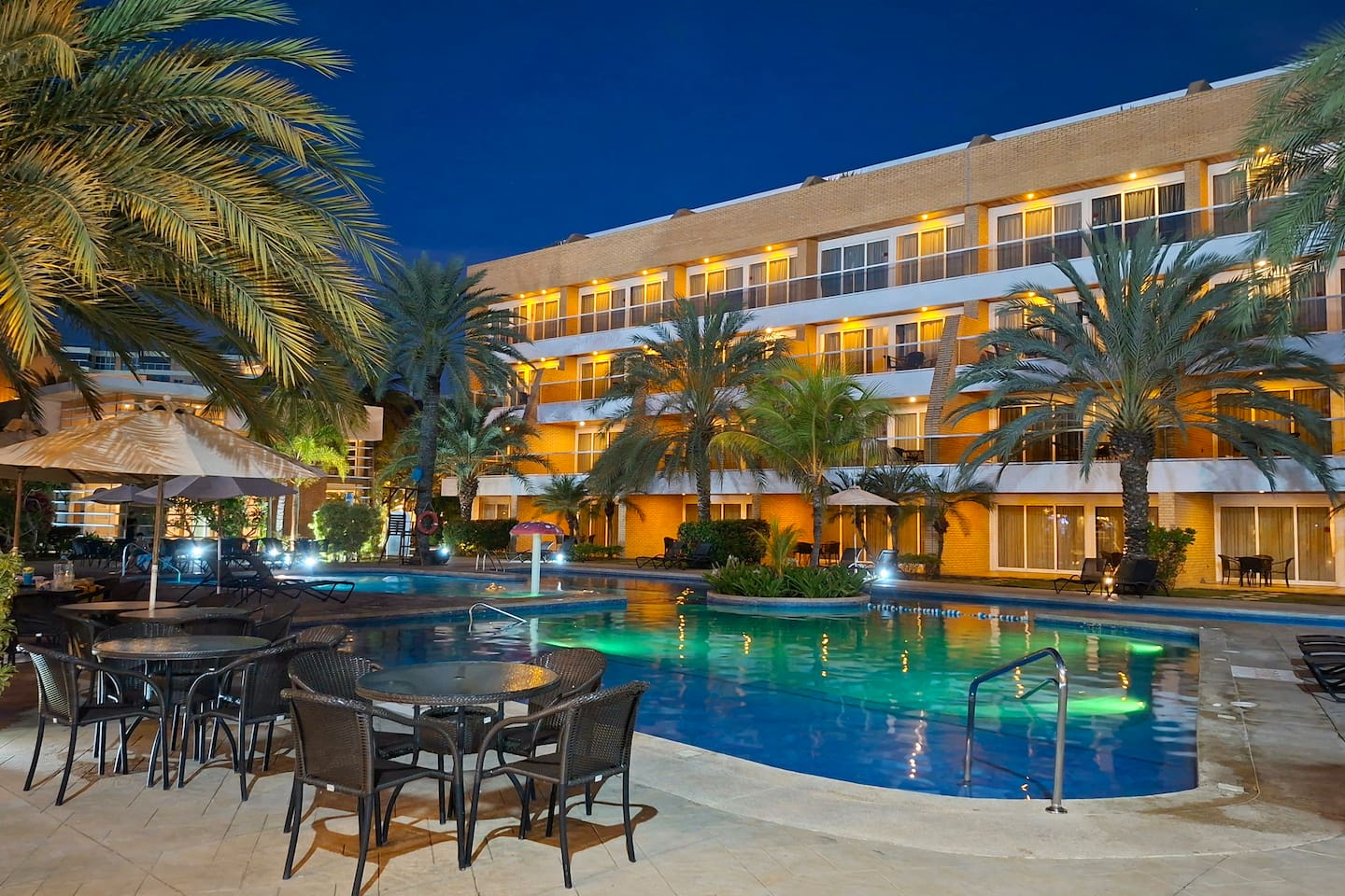 Enjoy the calm ambiance of the pool area, lit up at night for a relaxing atmosphere.