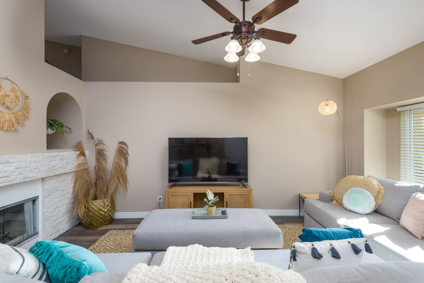 Living room with vaulted ceiling, large Smart TV, comfortable sectional seating, and room to relax or gather indoors.