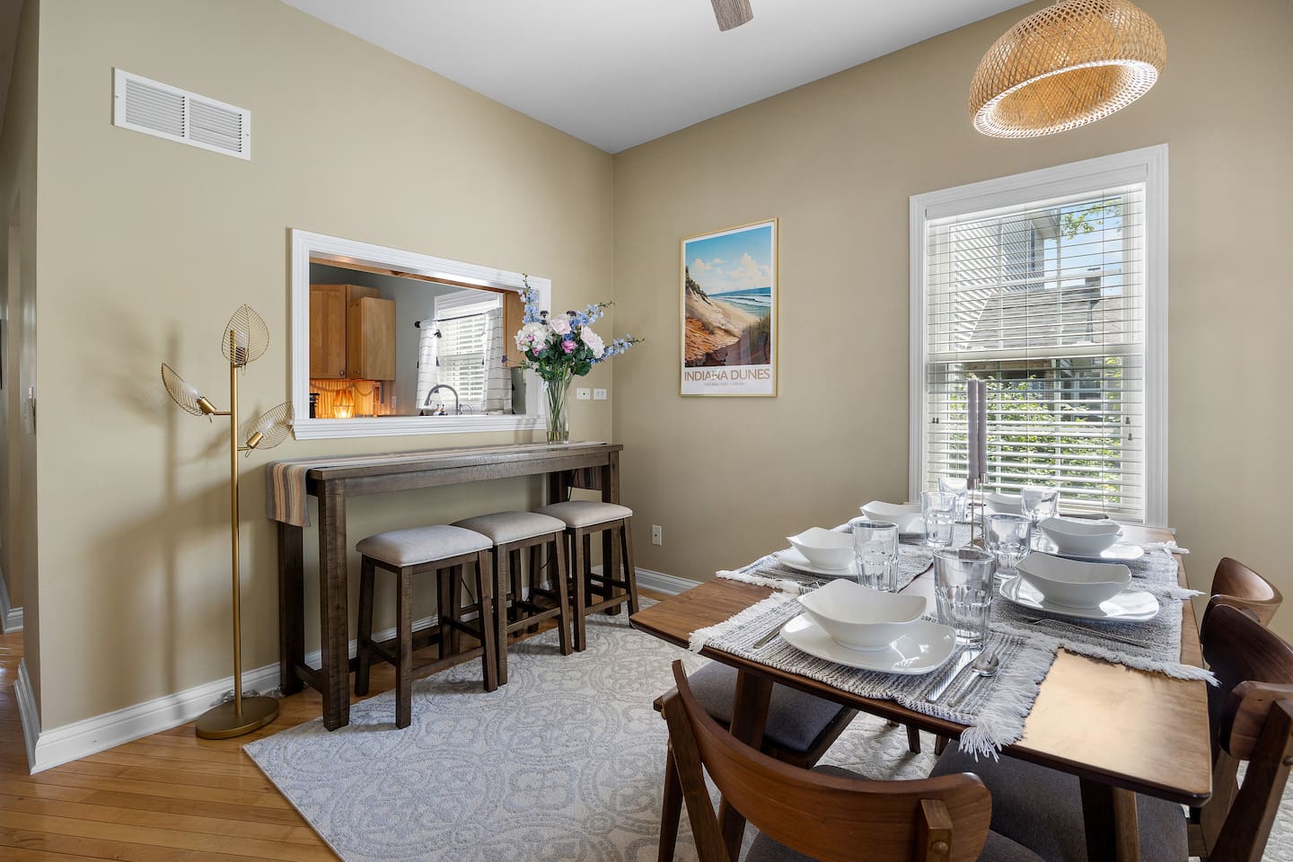 Dining table set for 6, with 3 additional bar stool seats at hightop counter by pass through window at kitchen. 