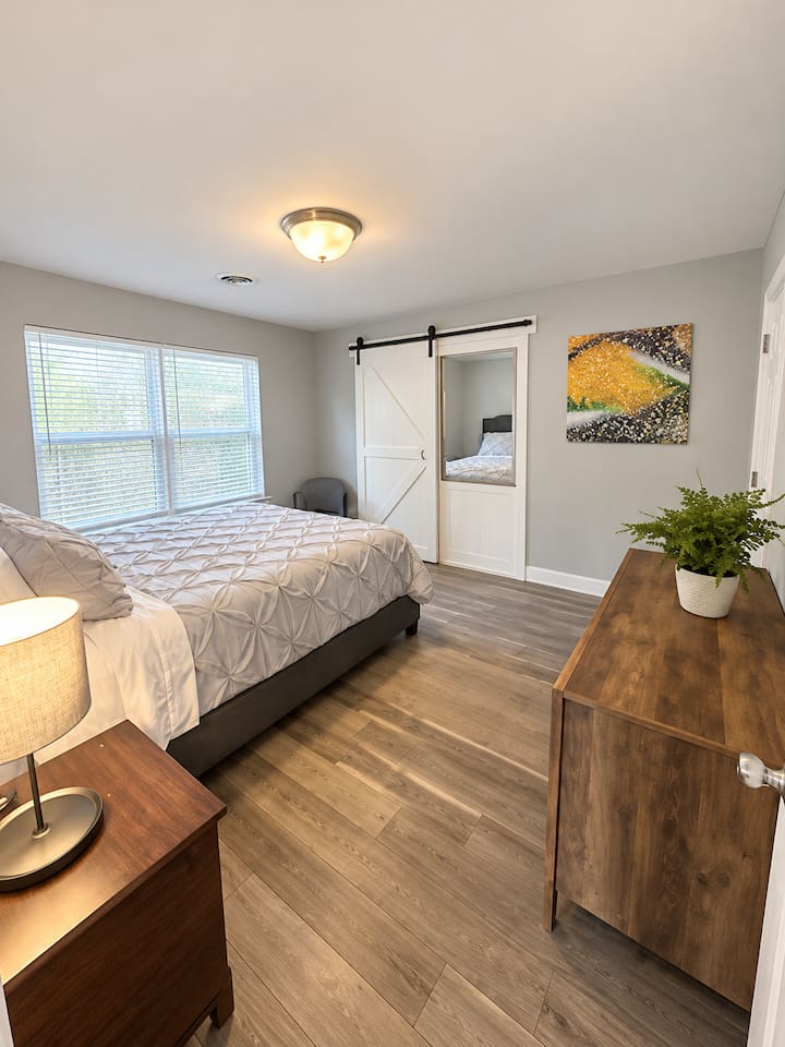 Bedroom Retreat: Tranquil space with natural light, comfortable queen bed with clean beddings and sleek wooden finishes.