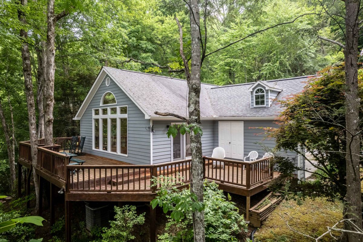 Exterior Retreat: Experience serene views from a spacious deck nestled among lush trees!

