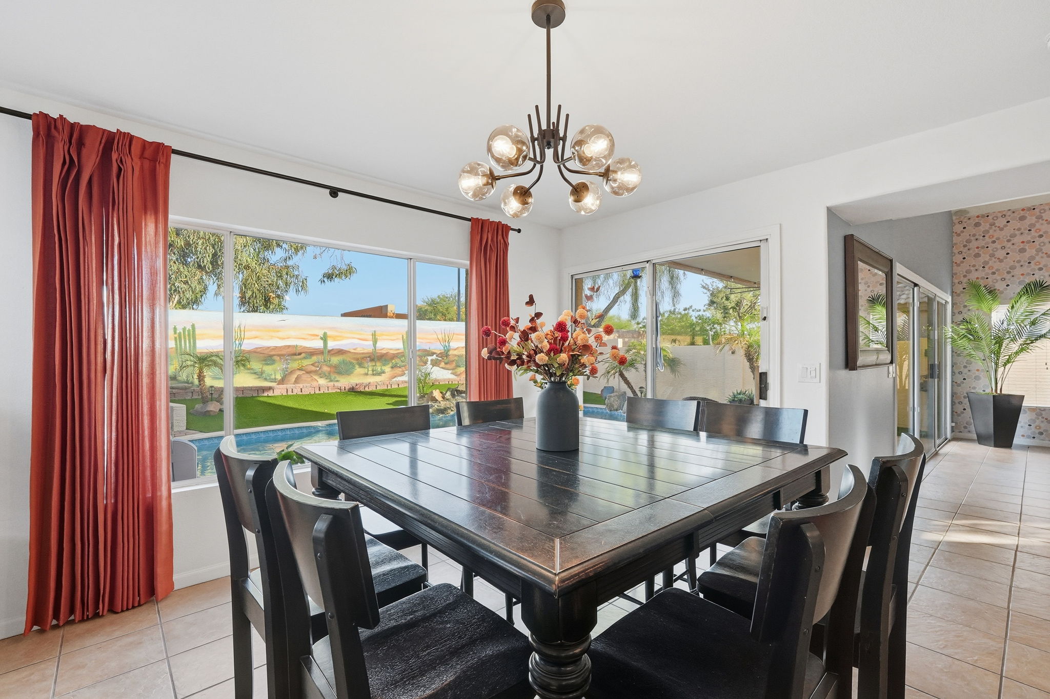 Dining area with table seating, patio access, and view to pool area 