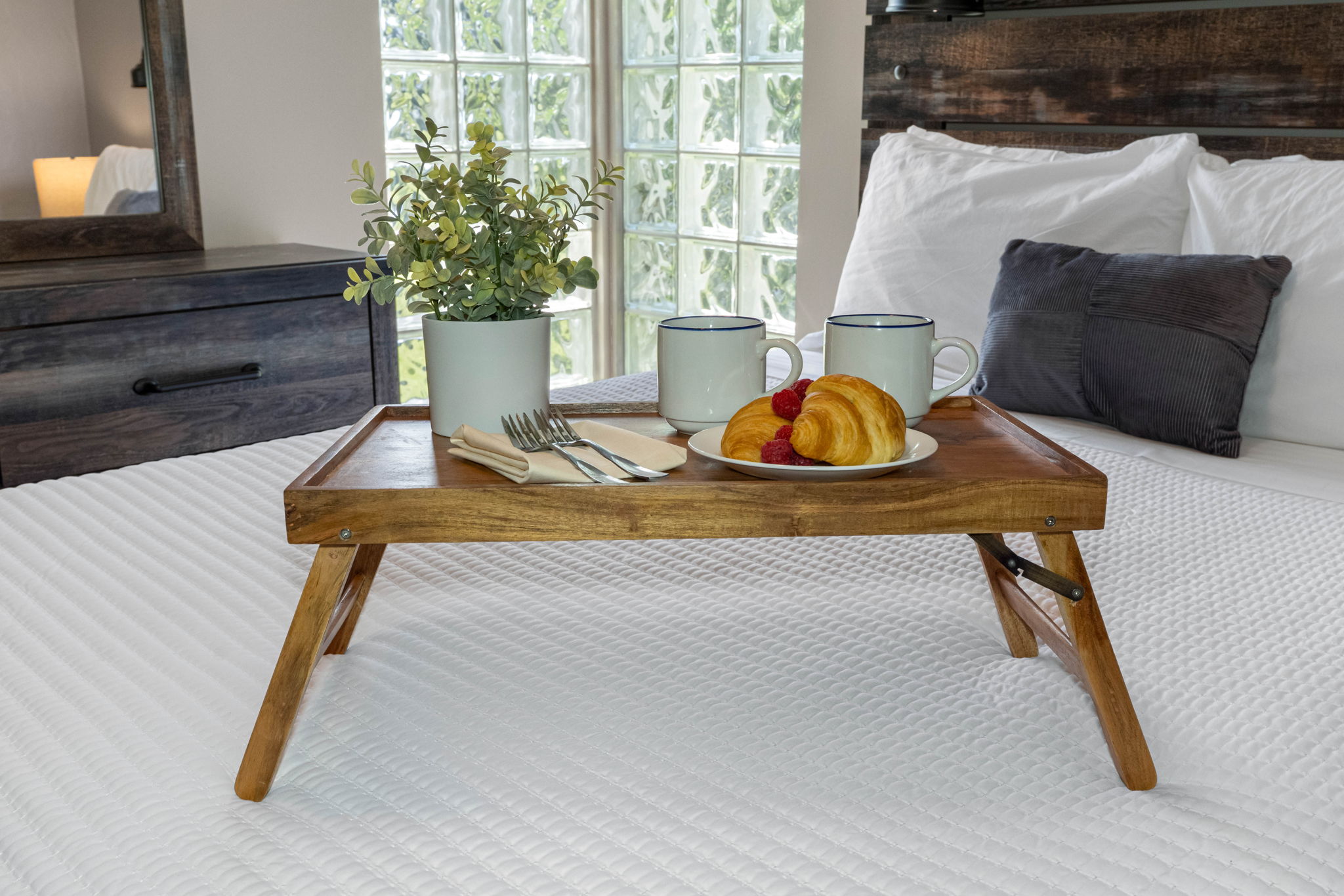 A blend of rustic wood finishes and sleek modern design creates a stylish yet comfortable bedroom retreat.