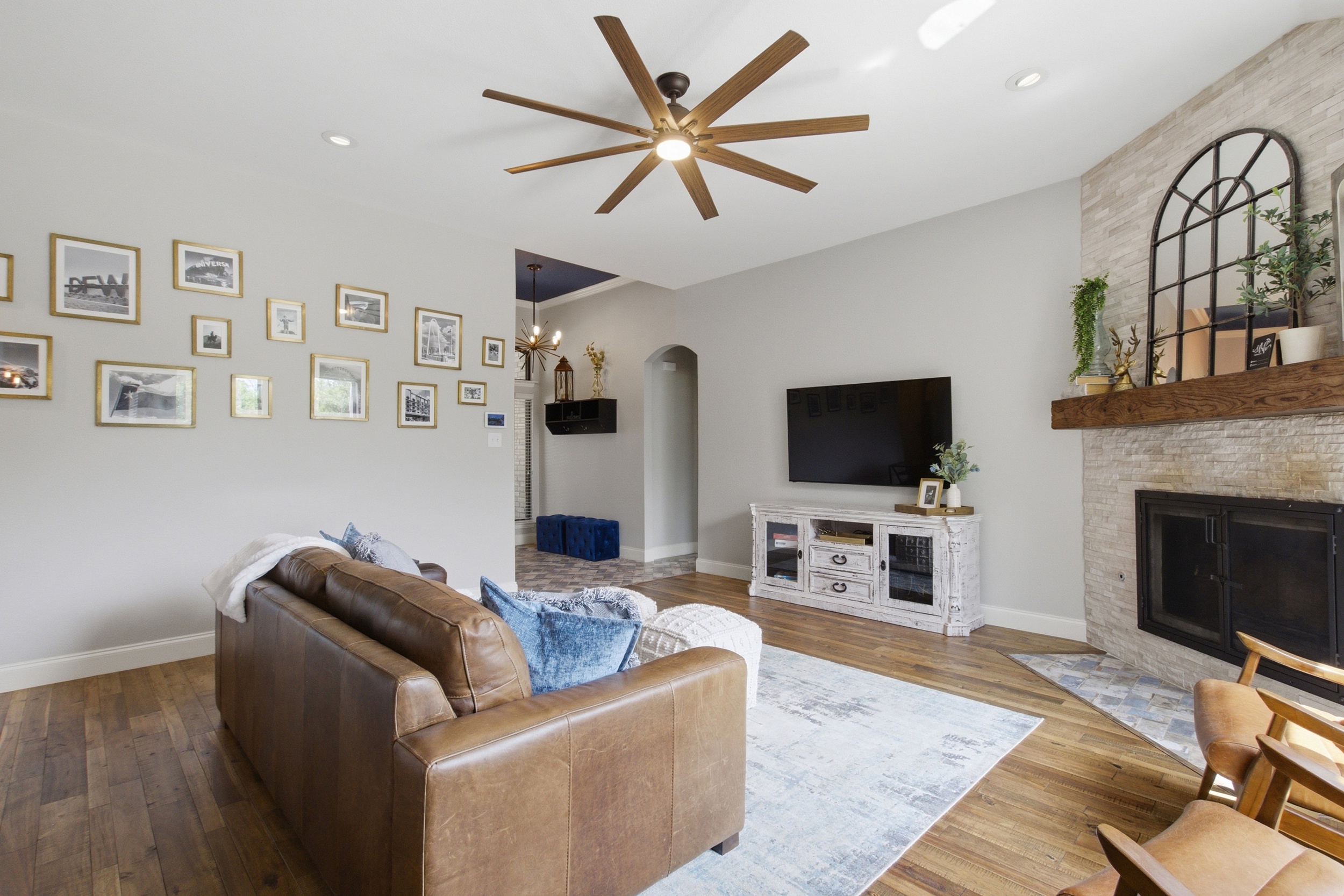 Spacious Living Room with comfortable seating, a curated gallery wall, and the wood-burning Fireplace as the focal point. Streaming and Smart TV access included.
