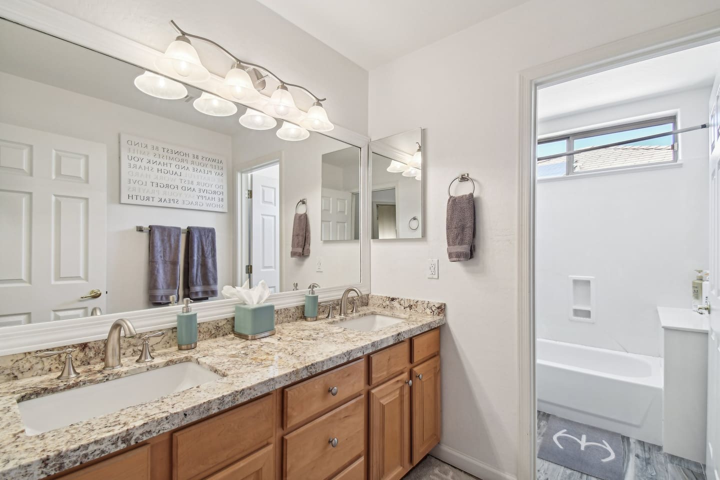 Enjoy a modern touch with this updated guest bathroom featuring a granite countertop, full mirror, and sleek walk-in shower with natural light.