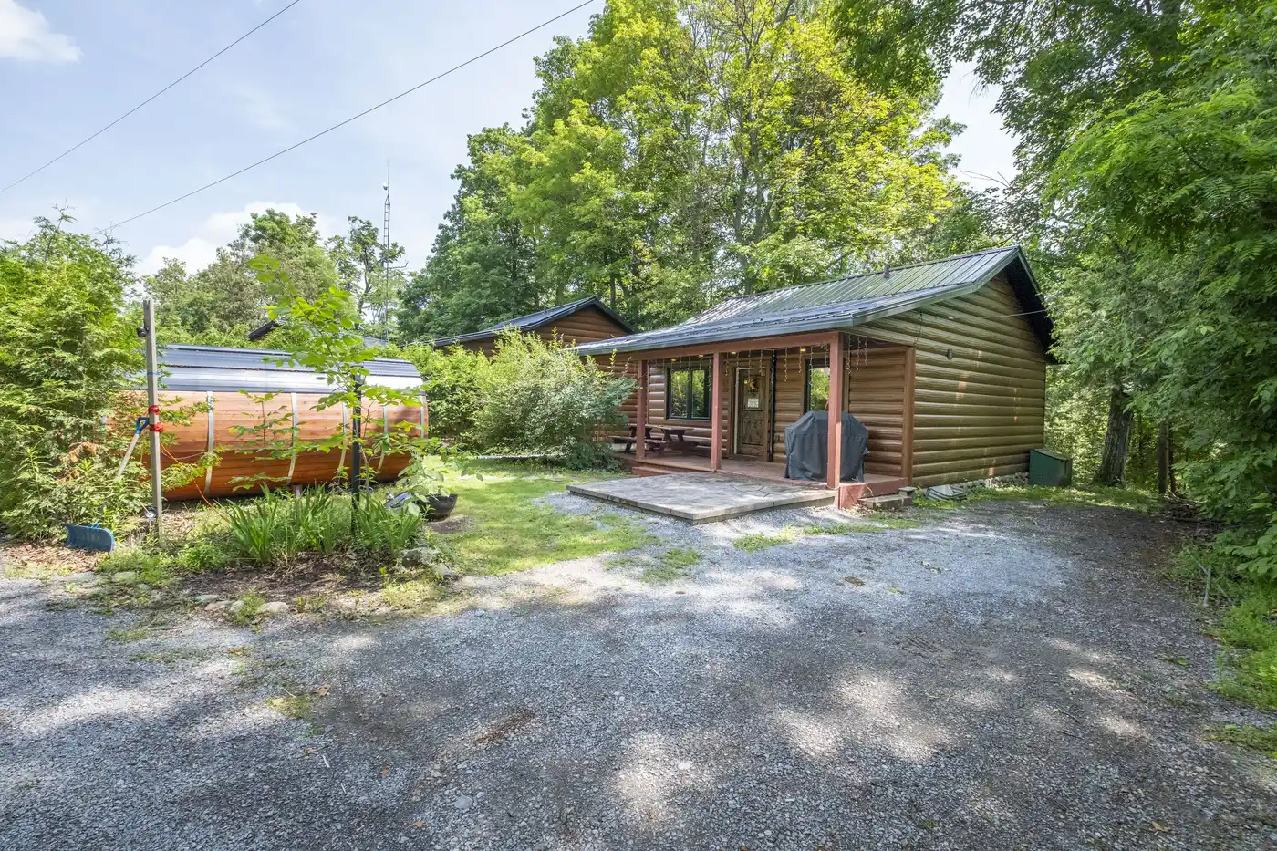 Cottage #6 exterior with driveway and surrounding greenery
