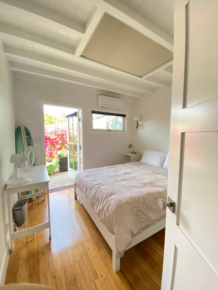 Bright bedroom with direct patio access and fresh natural light.