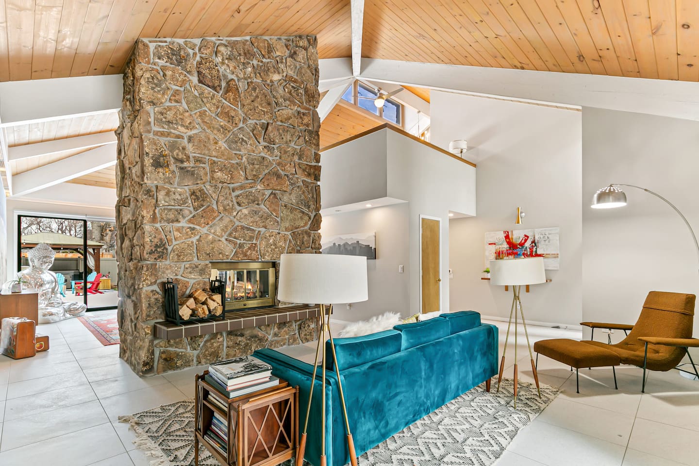 Welcome to the enchanting Living Room, furnished with a velvet sofa for intimate conversations, a two-sided fireplace, and easy access to the outdoor area, kitchen, and patio.