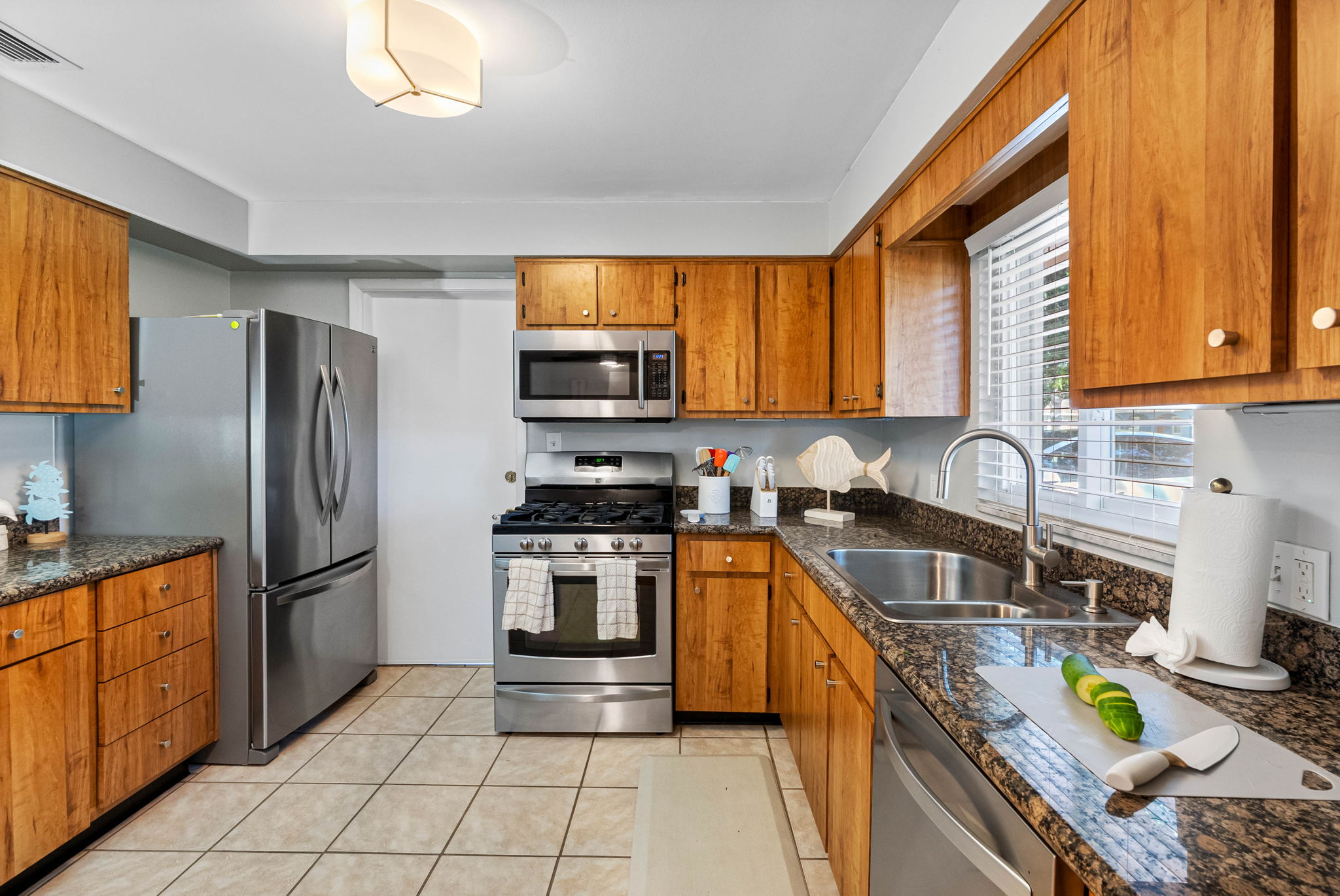 Granite countertops, gas stove, and dishwasher make cooking and cleanup a breeze in this practical space.