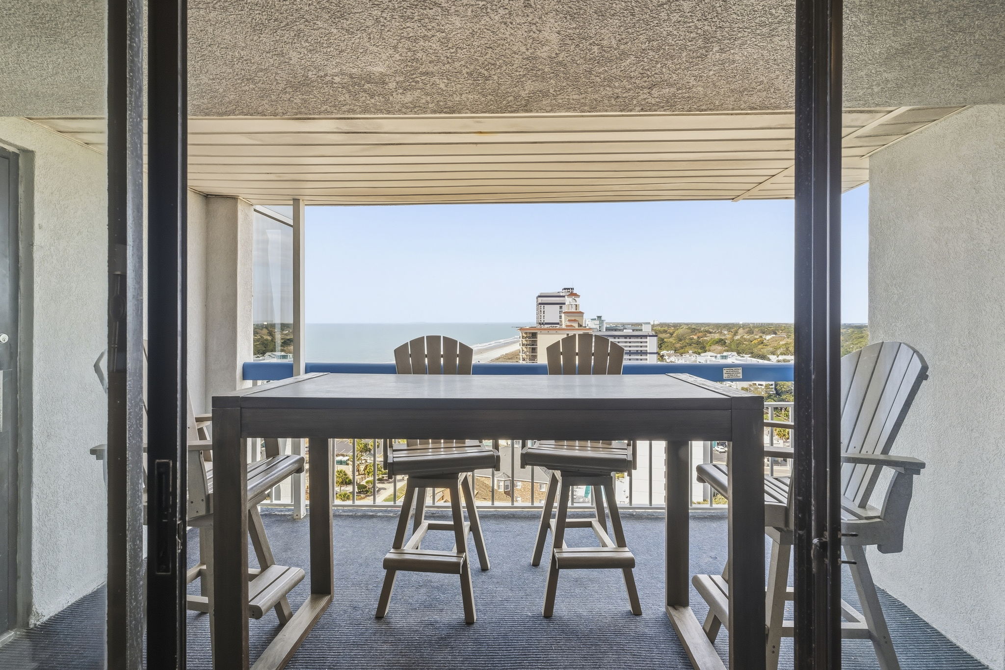 Covered balcony with high-top table and seating
