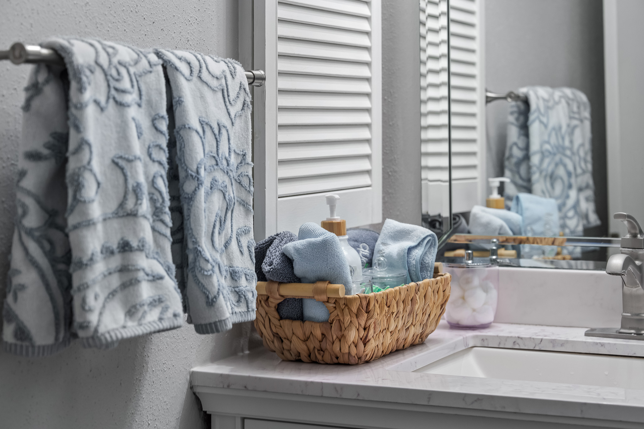 Thoughtfully stocked guest bathroom with soft rolled towels, refreshing lotion, and the extra touches you didn’t know you’d need—because comfort is in the details.