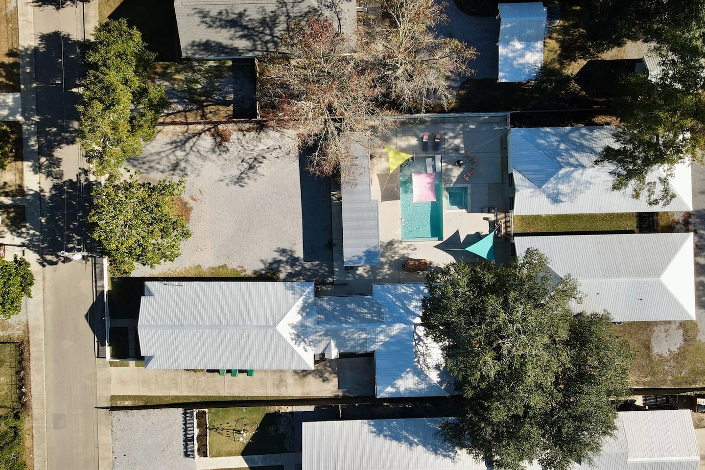 Top-down aerial view highlighting the pool courtyard surrounded by charming cottages.