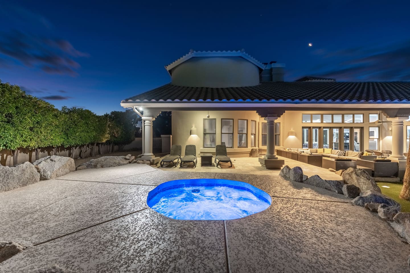 Soak in the illuminated hot tub as the sun sets, with cushioned loungers and outdoor seating just steps away.