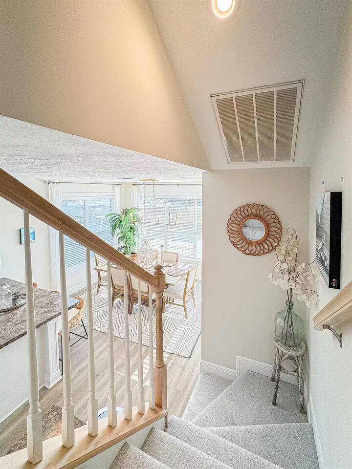 Airy stairway with natural light and stylish decor, offering a warm welcome and easy flow between levels.
