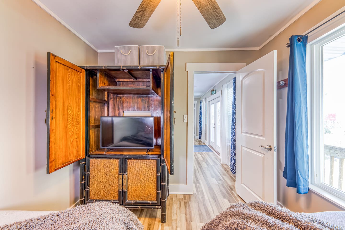 Bedroom Retreat: Vintage charm meets modern comfort with a sleek TV and serene coastal style!